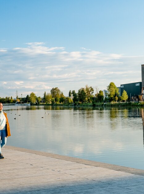 Zwei Frauen gehen am Flussufer entlang - bei Sonnenuntergang in Graz. | © Graz Tourismus