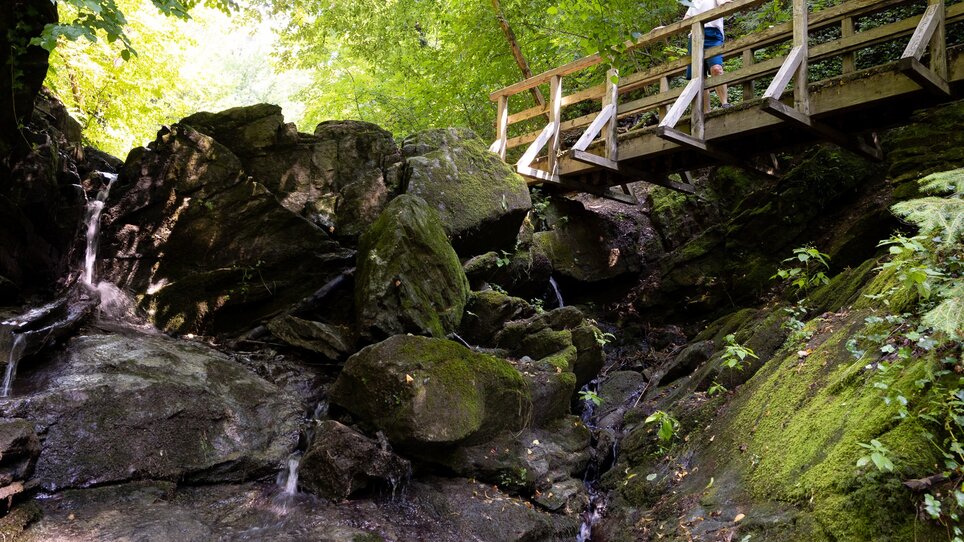 Eine Wanderung in der Rettenbachklamm mit Brücke über den Wasserfall und grüner Natur. | © Graz Tourismus
