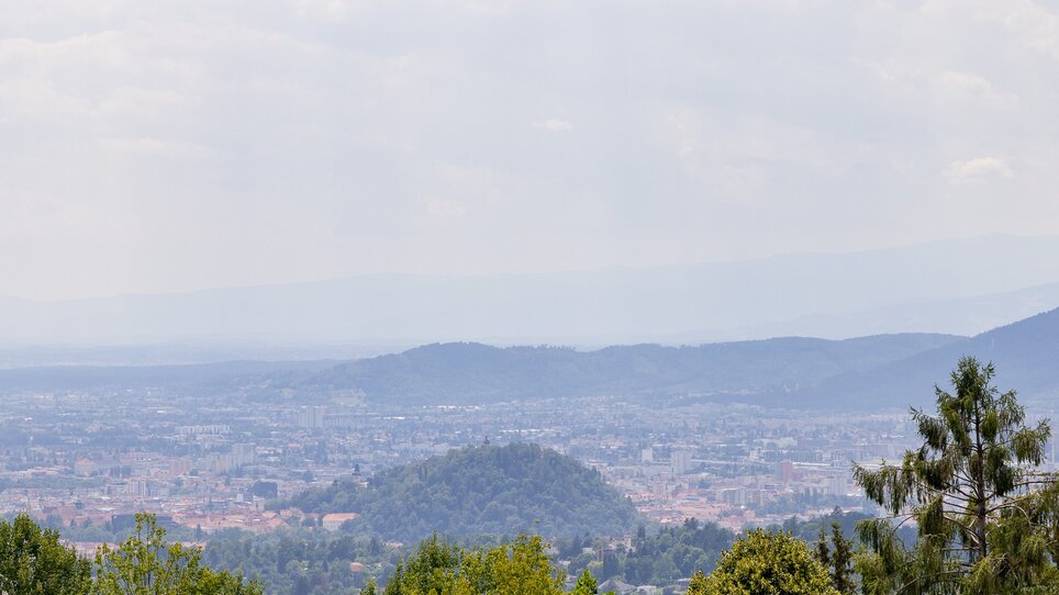 Blick über Graz mit Bergen und Wolken am Himmel. | © Graz Tourismus