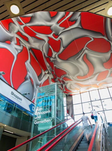 Moderne Treppe mit künstlerischem Deckendesign im Hauptbahnhof Graz. | © Graz Tourismus - Harry Schiffer