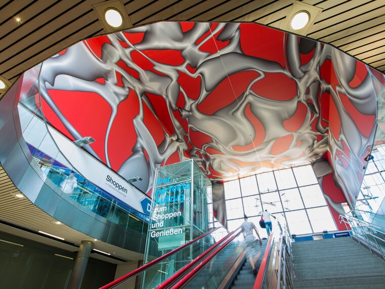 Moderne Treppe mit künstlerischem Deckendesign im Hauptbahnhof Graz. | © Graz Tourismus - Harry Schiffer