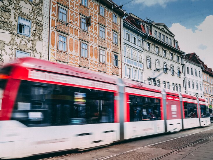 A tram in Graz passes by a colorful façade at Graz’s Main Square. The Swarovski shop can be seen in the background. | © Janet Newenham-Journalist on the Run