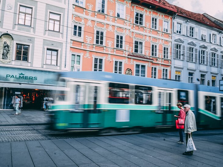 A green tram passes by as pedestrians stand outside the Palmers store. | © Janet Newenham - Journalist On The Run