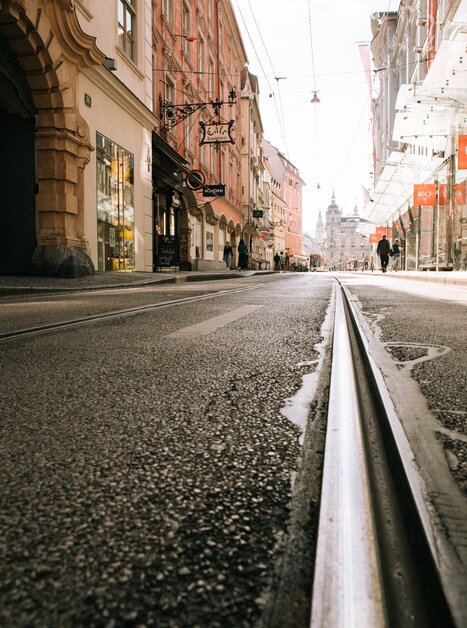 Ansicht der Sackstraße in Graz mit Straßenbahnschienen und Geschäften. | © Graz Tourismus
