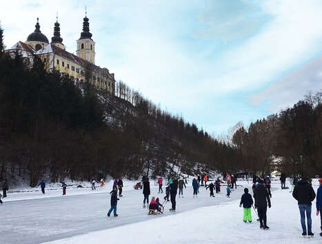 Menschen genießen das Eislaufen vor der Basilika Mariatrost in der Winterlandschaft. | © Stadt Graz - Sportamt