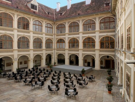Cortile accogliente con tavoli e sedie per gli ospiti. | © Universalmuseum Joanneum