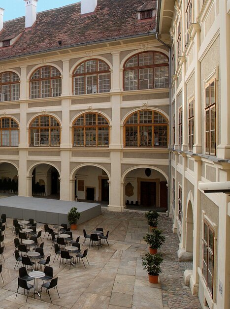 Cortile accogliente con tavoli e sedie per gli ospiti. | © Universalmuseum Joanneum