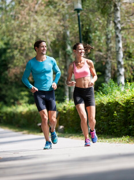 Ein Mann und eine Frau joggen entspannt in einem Park. | © Region Graz - Tom Lamm
