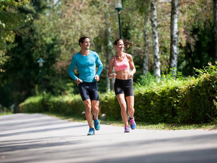 Ein Mann und eine Frau joggen entspannt in einem Park. | © Region Graz - Tom Lamm