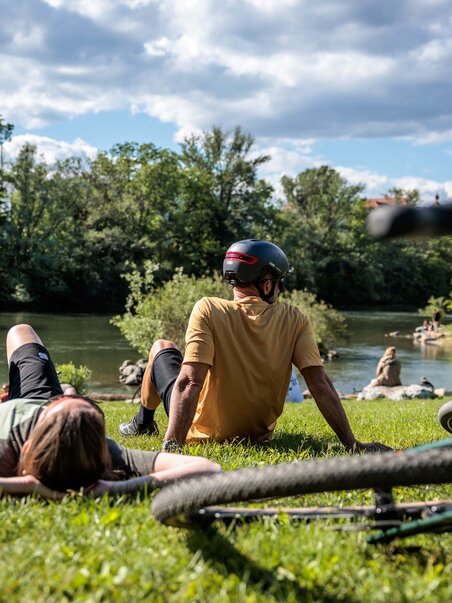 Two people relaxing by the shore of a body of water. | © Region Graz - Erwin Haiden