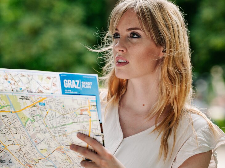 Woman with city map in Graz, searching for direction and exploring. | © Graz Tourismus - Mias Photoart
