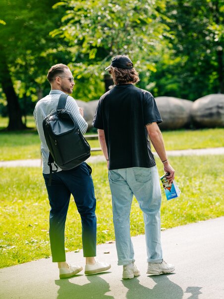 Two men in the Augarten park in Graz, one wearing sunglasses and carrying a rucksack, the other holding a city map. | © Graz Tourismus - Mias Photoart
