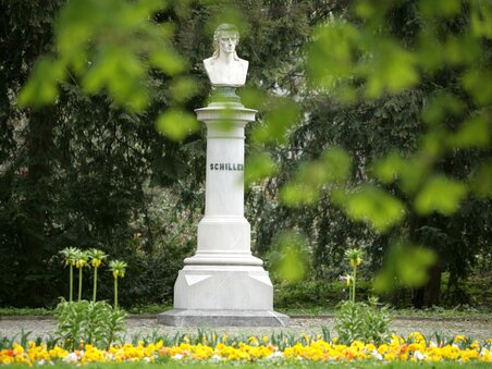 A bust of Schiller surrounded by colorful flowers in the city park. | © Graz Tourismus - Harry Schiffer