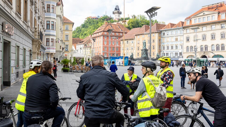 Gruppe von Radfahrern in Graz mit dem Uhrturm im Hintergrund. | © Graz Tourismus - Harry Schiffer
