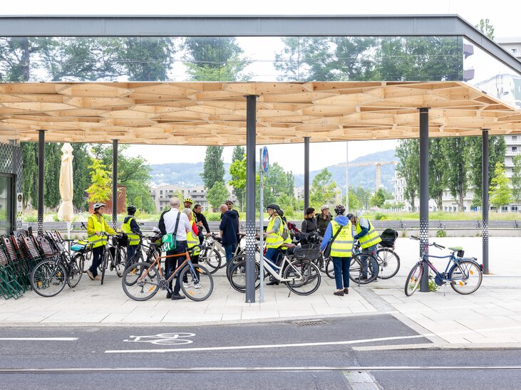 Cyclists gather under a modern canopy in Graz. | © Graz Tourismus - Harry Schiffer