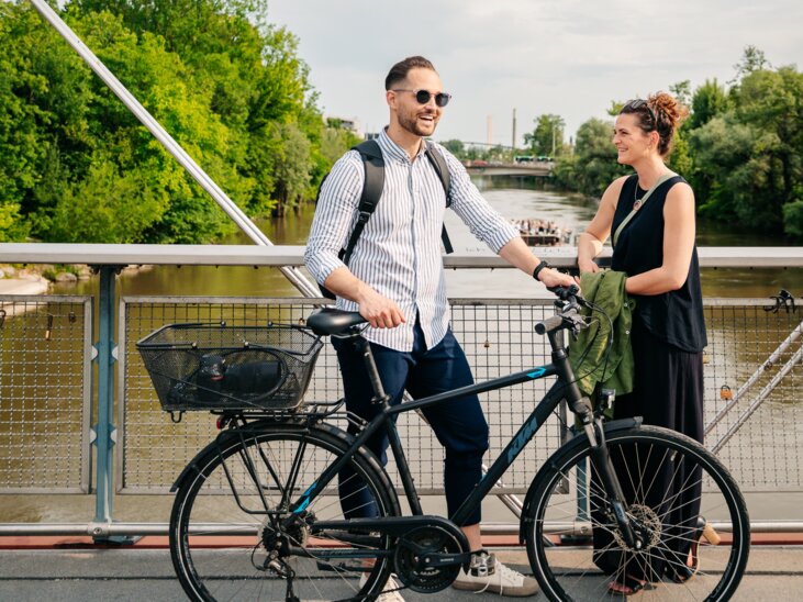 A couple talking on a bridge over the Mur. | © Graz Tourismus - Mias Photoart