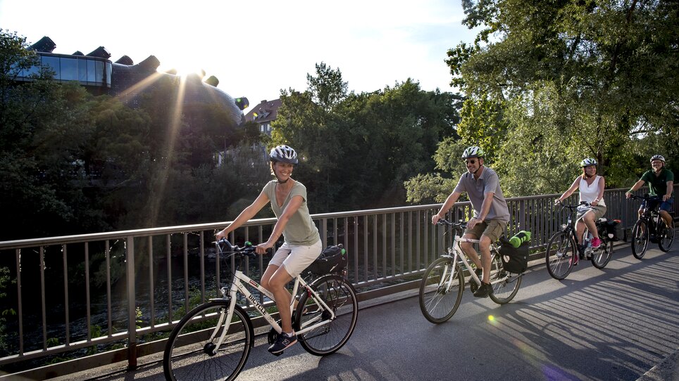 Verschiedene Fahrradfahrer genießen eine Radtour in Graz entlang der Mur. | © Graz Tourismus - Tom Lamm