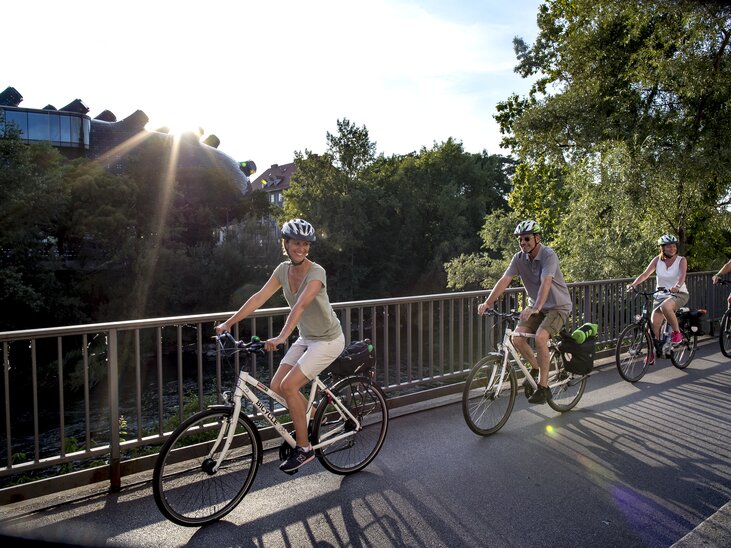 Diversi ciclisti si godono un giro a Graz lungo il fiume Mur. | © Graz Tourismus - Tom Lamm