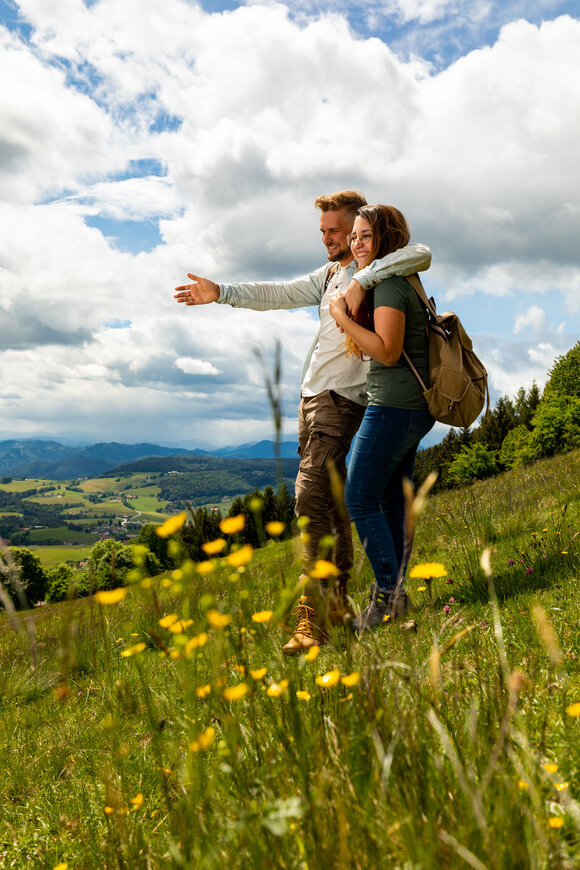 A couple enjoys the view in nature, embracing and smiling. | © Region Graz - Harry Schiffer
