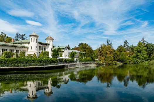 Ein malerisches Gebäude am Grazer Hilmteich spiegelt sich im Wasser. | © Graz Tourismus - Mias Photoart