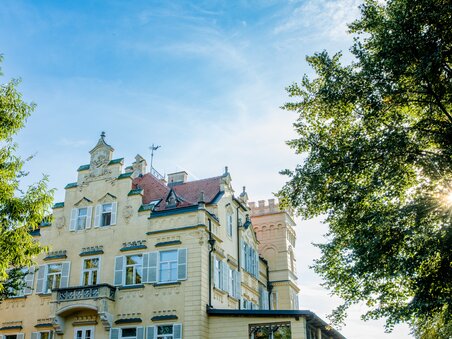 Schloss Lustbühel with towers and trees under a bright sky in Graz. | © Graz Tourismus - Mias Photoart