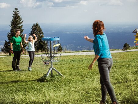 Familie spielt Disc Golf am Schöckl mit Blick auf die Berge. | © Holding Graz - Lex Karelly