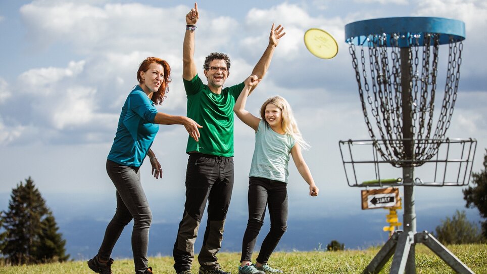 Fröhliche Familie spielt Frisbee-Disc Golf am Schöckl in Graz. | © Holding Graz - Lex Karelly