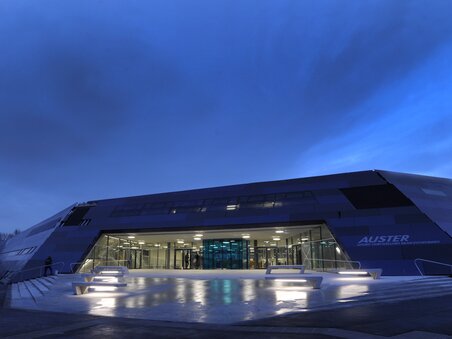 Futuristisches Schwimmbadgebäude Auster in Graz bei Dämmerung. | © Holding Graz - Helge Sommer