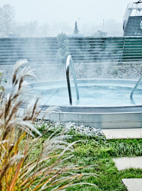 Outdoor hot tub with steam, surrounded by plants in Graz. | © Holding Graz - Lupi Spuma
