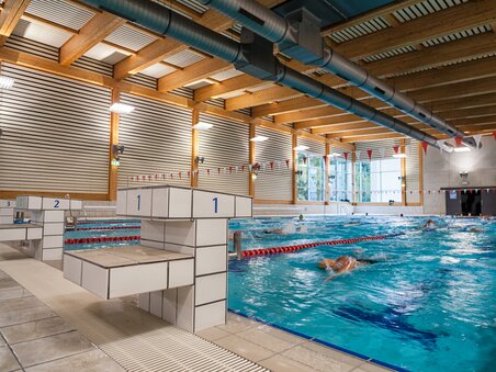 Interno della piscina coperta Sport Union con nuotatori in acqua. | © Michael Jöbstl