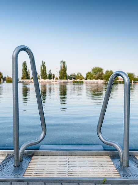 Una vista dell'acqua calma al Bad Straßgang con una scala per l'ingresso. | © Holding Graz - Joel Kernasenko