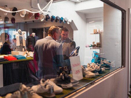 Zwei Männer schauen Schuhe in einem Golfgeschäft an. | © GEPA I RUFF Golf Graz