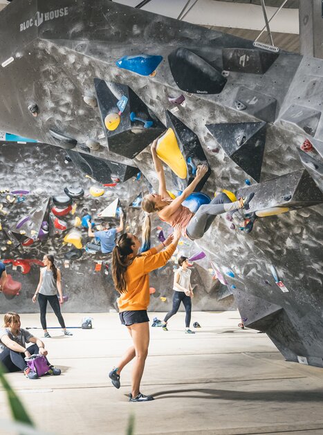 Bouldern in der Kletterhalle mit Zuschauern und Trainern. | © byAchimR