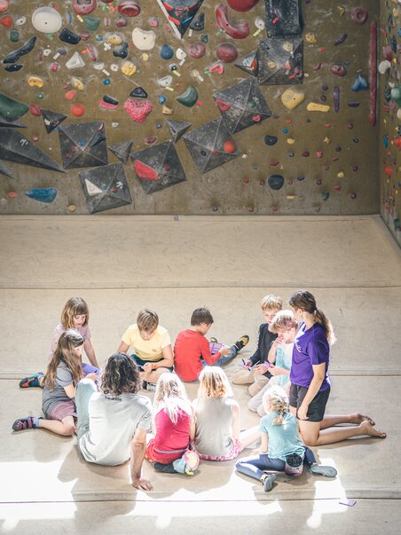 Eine Gruppe von Kindern sitzt im Kletterbereich und lernt. | © byAchimR