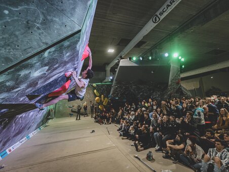 Ein Kletterer beim Wettkampf in der BLOC house Graz Kletterhalle, vor einem begeisterten Publikum. | © byAchimR