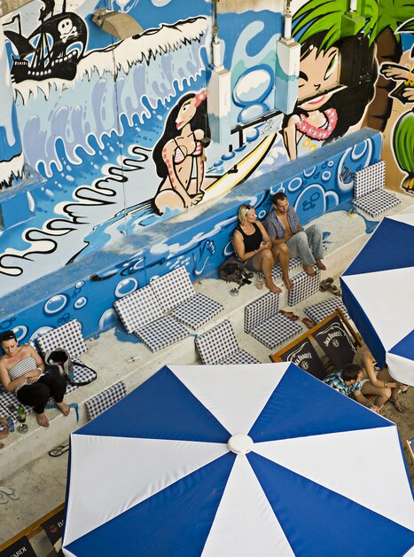 View of a beach bar featuring graffiti and sun loungers. | © Toni Muhr