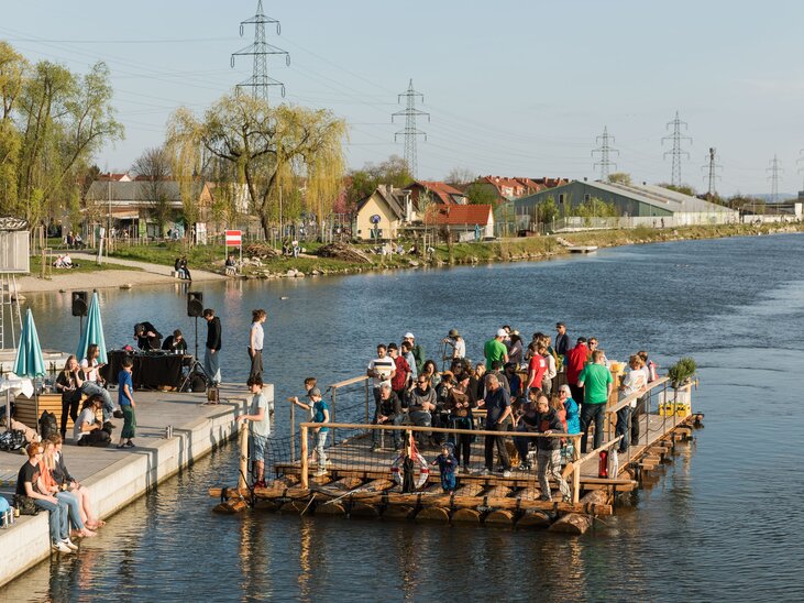 Persone su una zattera a Graz, fiume Mur, all'aperto in una giornata di sole. | © LippZahnschirm