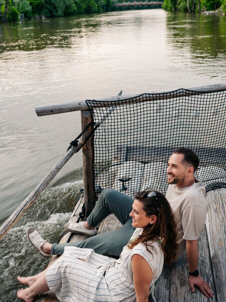 Couple sitting by the river enjoying the view while rafting. | © Graz Tourismus - Mias Photoart