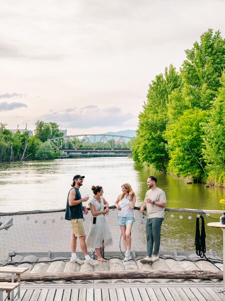 Group of friends enjoying time by the river in Graz, surrounded by trees. | © Graz Tourismus - Mias Photoart