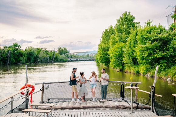Gruppe von Freunden genießt Zeit am Fluss in Graz, umgeben von Bäumen. | © Graz Tourismus - Mias Photoart