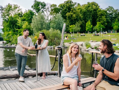 Friends enjoying drinks on a raft on the Mur River in Graz with fine weather. | © Graz Tourismus - Mias Photoart