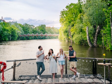 Four friends enjoy drinks on a raft on the Mur in Graz. | © Graz Tourismus - Mias Photoart