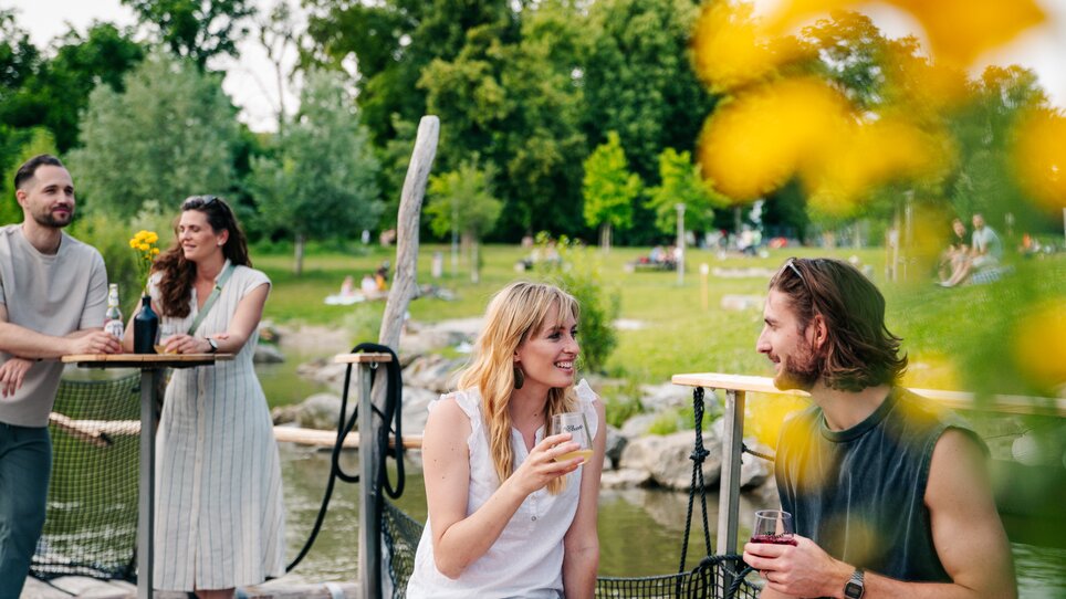 Relaxing time with friends by the water with drinks and flowers. | © Graz Tourismus - Mias Photoart