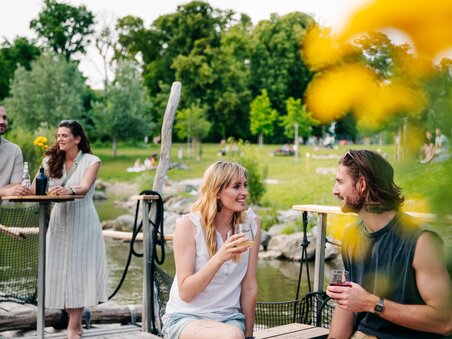 Relaxing time with friends by the water with drinks and flowers. | © Graz Tourismus - Mias Photoart