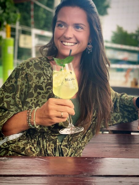 A woman holding a drink, smiling at Mur Beach in Graz. | © Mur Beach - Ingo Gruber