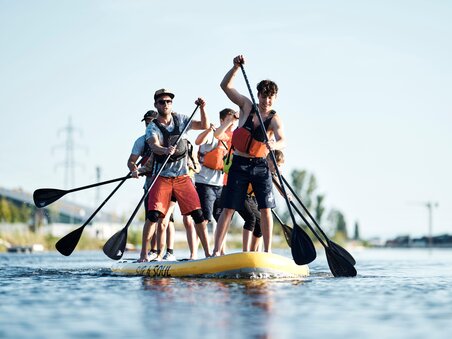 Group of people paddling on a large SUP in the water. | © Stadtstrand Graz - Stefan Leitner