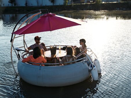 Group of friends in a round boat on the river Mur in Graz at sunset. | © Stadtstrand Graz - Stefan Leitner