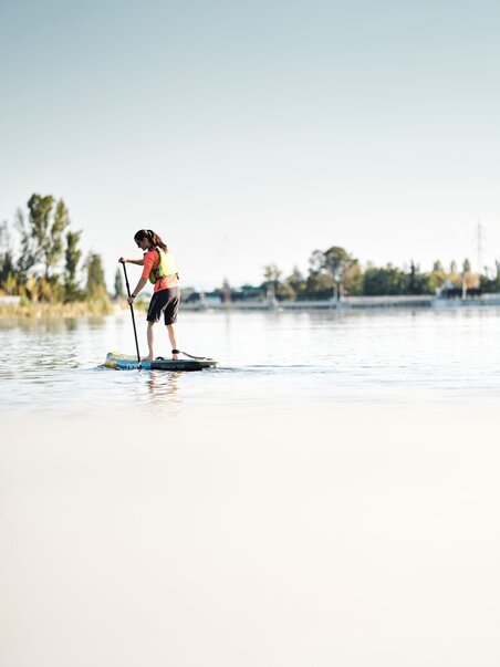 A girl paddleboarding on calm water. | © Stadtstrand Graz - Stefan Leitner