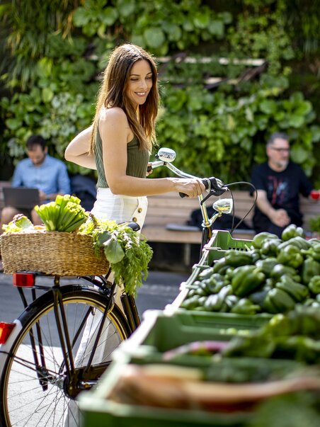 Frau mit Rad kauft frisches Gemüse am Kaiser Josef Markt in Graz. | © Graz Tourismus - Tom Lamm