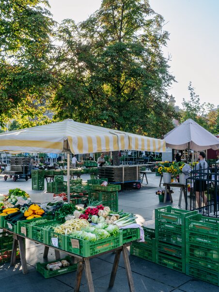 Bauernmarkt am Grazer Lendplatz mit Ständen mit buntem Gemüse unter Sonnenschirmen. | © Graz Tourismus - Mias Photoart